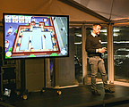 Mann stehend auf Bühne mit Bildschirm im Hintergrund